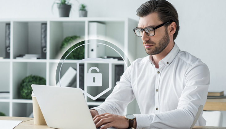 Man in front of laptop with security symbols